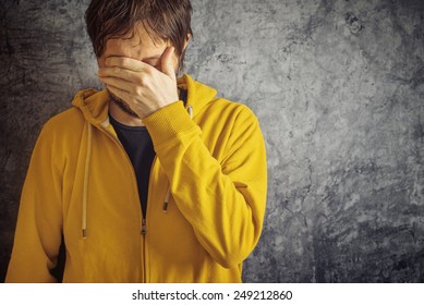 Adult Man with Chronic Migraine Headache Wearing Yellow Jacket.