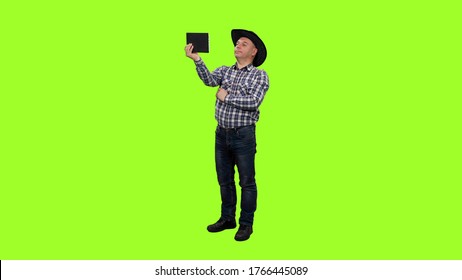 Adult Man In Cowboy Hat Taking Selfie With Ipad On Green Screen Background, Chroma Key