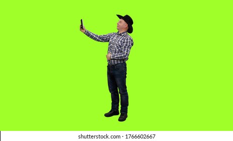 Adult Man In Cowboy Hat Taking Selfie With Ipad Against Green Screen Background, Chroma Key