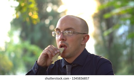 Adult Man Eating Healthy Organic Granola Bar In Park