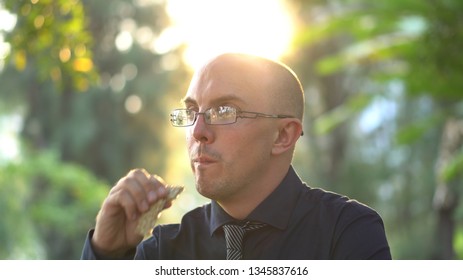 Adult Man Eating Healthy Organic Granola Bar In Park