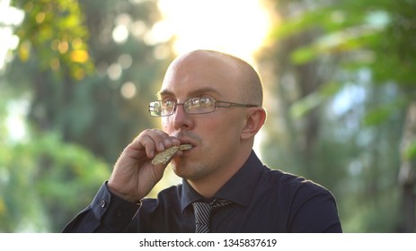 Adult Man Eating Healthy Organic Granola Bar In Park