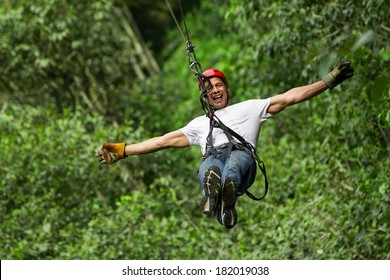 An adult man enjoying an adrenaline-filled ziplining adventure through the lush forests of Ecuador, soaring along a thrilling zip line. - Powered by Shutterstock