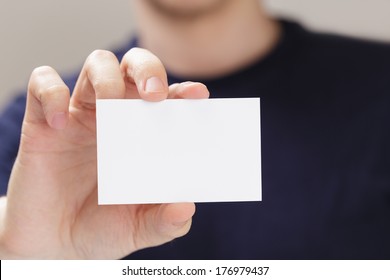 Adult Man Hand Holding Empty Business Card In Front Of Camera, Blurred Background