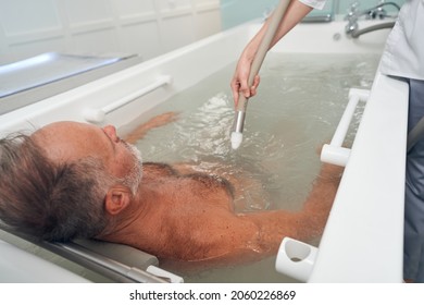 Adult man having hydromassage procedure at spa center