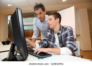 Adult Man Helping Student In Classroom