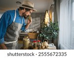 Adult man herbalist in apron test organic natural homemade soap in workshop