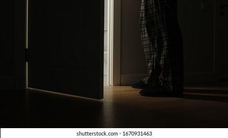 Adult Man In A Pajamas Walks To A Bathroom In The Night