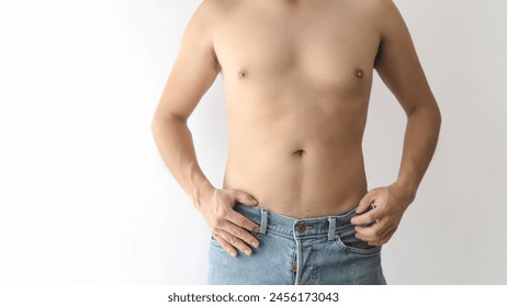 A Adult man with partially toned abdomen, shirtless, wearing blue jeans, white background, and space for text. - Powered by Shutterstock