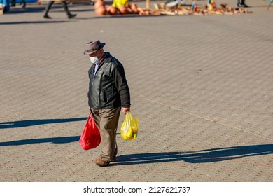 An Adult Man With Purchases Comes From The City Fair. November 11, 2021 Balti Moldova. For Editorial Illustrative Use. Background With Copy Space For Text