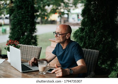 
an adult man sitting in a cafe and working on a laptop - Shutterstock ID 1794735307