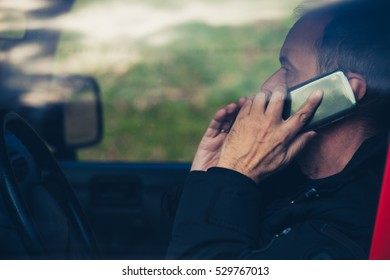 adult man speak on smartphone in car close