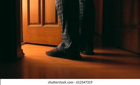 Adult Man Stands Near Door To A Bathroom At The Night 