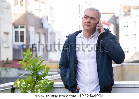 adult man talking with mobile phone in the street