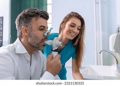 Adult man testing breathing function by spirometry having health problem. Diagnosis of respiratory function in pulmonary disease.
