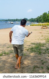 Adult Man Throwing Horseshoe Game Beach Activity QC Canada