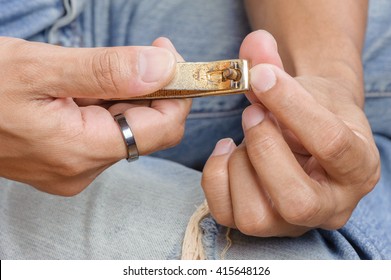 Adult Man Trimming His Nails With Nail Clipper. 