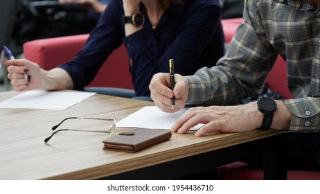 Adult Man And Woman Fill Out Paperwork Or Forms. The Concept Of Divorce Proceedings, Signing A Marriage Contract, Agreement Or Notarized Power Of Attorney. No Face