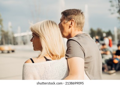 An Adult Mature Happy Romantic Couple In Love Outdoors In City Street Park. A Blonde Caucasian Man And Woman Spend Time Together. Senior Wife And Husband Walking Outside On Square