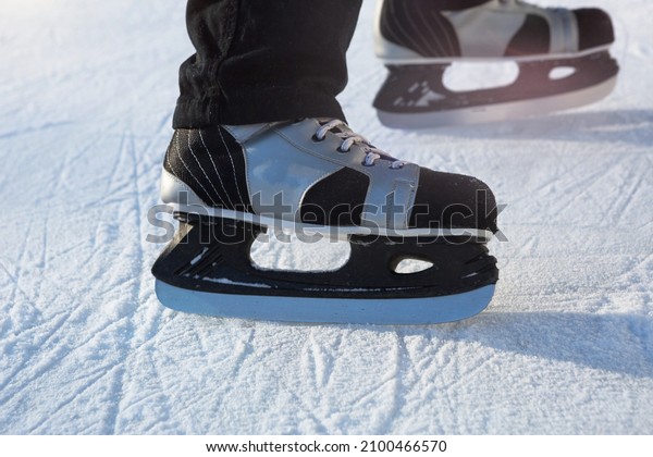 Adult Men\'s Ice Skates close-up on Ice in\
Winter outdoor on the move. Rolling and sliding in frosty sunny\
day, active winter sports and\
lifestyle