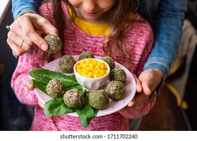 Adult Mother And Child Girl Have Food Together. Family Vegan Food And Care Concept. Pkhali - Green Georgian Falafel Balls Cold Snack And Sweet Corn