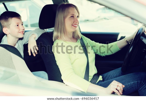 Adult mother and son driving in city during\
sightseeing tour