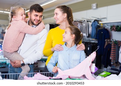 Adult Parents Choosing New Turtleneck For Daughters In Children Clothing Shop