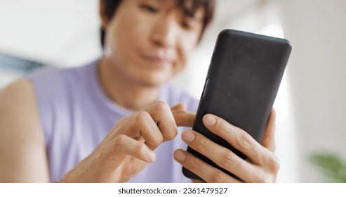 Adult people asia single LGBT gay man sitting at home sofa looking at dating game tinder app on mobile phone. Relax smile choose lover enjoy playing right swipe to find love couple match flirt chat. - Powered by Shutterstock