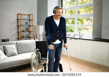 Adult Person With Disability Paralysis And Crutches After Injury