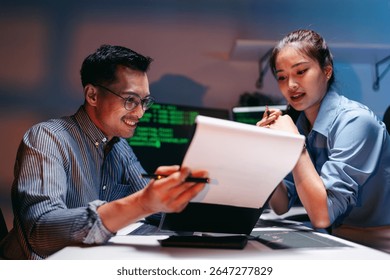 Adult professionals analyze financial data and code AI solutions during focused night work. Their collaborative effort drives innovation business growth.