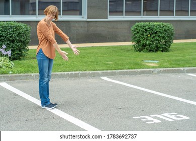 An Adult Red-haired Woman Gestures With Both Hands To An Empty Parking Space. Concept - Car Theft Or Confiscation Or Forgotten Parking Space