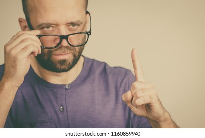 Adult rude man wearing eyeglasses being overbearing, commanding pointing with his finger