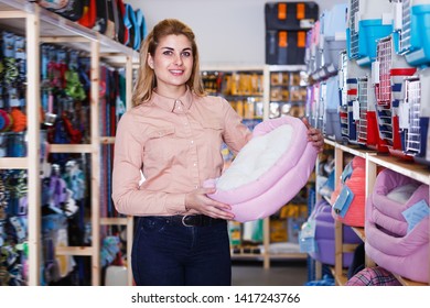 Adult Saleswoman Offering Pet Bed In Pet Store