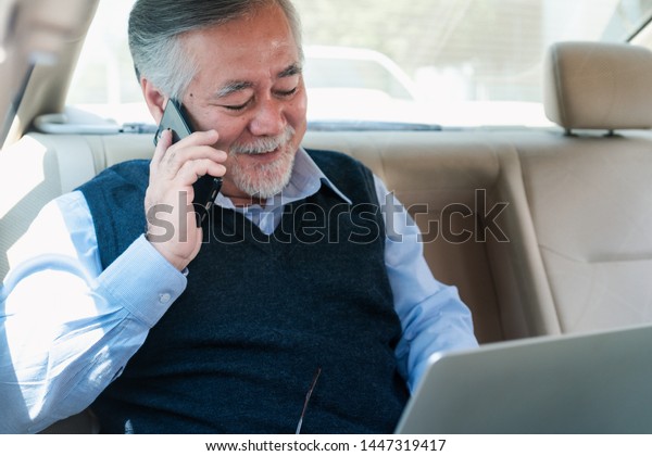 Adult senior executive luxury business old man\
sitting with laptop computer at back of car seat ,Technology\
transport lifestyles\
concept.