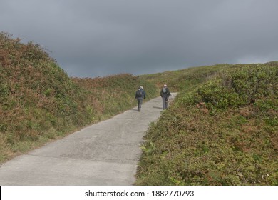 Adult Senior Male and Female Walking Uphill Along a Coastal Path on the Island of Tresco in the Isles of Scilly, England, UK - Powered by Shutterstock