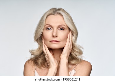 Adult Senior Older Woman Touching Her Perfect Skin. Beautiful Portrait Mid 50s Aged Woman Advertising Facial Anti Age Lift Products Salon Care Tighten Skin Isolated On White Looking At Camera.