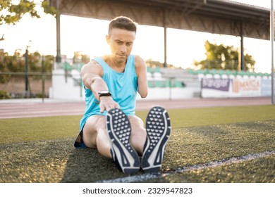 An adult senior soccer player with an amputated arm stretches his legs lying on the ground. Concept of disabled footballers, athletes with an amputated arm. Determination and overcoming. - Powered by Shutterstock