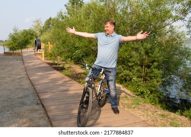 An Adult Smiling Man Bicycle Calls A Friend With A Hand Gesture.