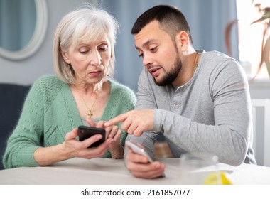 Adult Son Help An Elderly Mother Learn How To Use A Smartphone