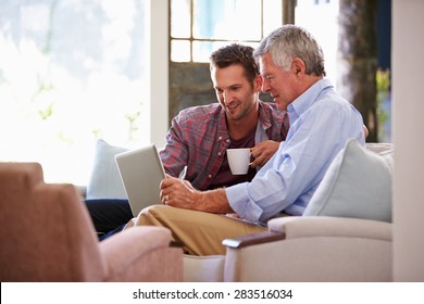 Adult Son Helping Senior Father With Computer At Home