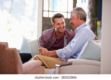 Adult Son Helping Senior Father With Computer At Home