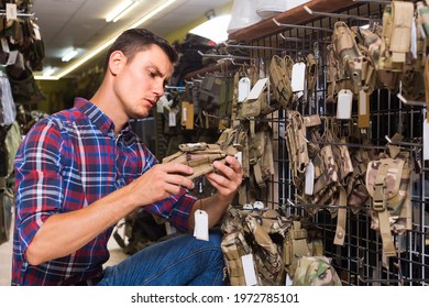 Adult Spanish Guy Looking Holster For Pneumatic Weapon In Army Store