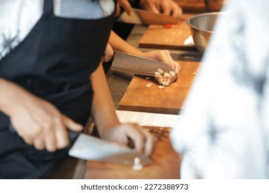 Adult students learning recipe and preparing meal in cooking class - Powered by Shutterstock