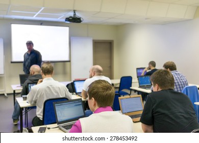 Adult Students Sitting In A Classroom, Using Laptop Computers During Class