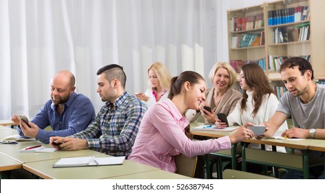 Adult students taking notes on smartphones at training session for employees. Focus on girl - Shutterstock ID 526387945