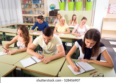 Adult students in university taking notes in their copybooks in cozy classroom - Shutterstock ID 528456907