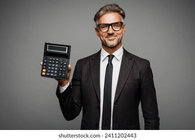 Adult successful employee business man corporate lawyer wear classic formal black suit shirt tie work in office use show calculator with blank screen isolated on plain grey background studio portrait - Powered by Shutterstock