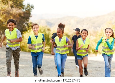 Adult Team Leader With Children At Outdoor Activity Camp Volunteering To Help With Environment