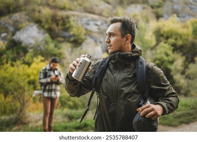 Adult tired and exhausted man hiker rest from hiking and use the moment to hydrate - Powered by Shutterstock