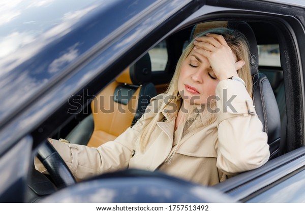 adult\
tired woman drives a car. depression while\
driving